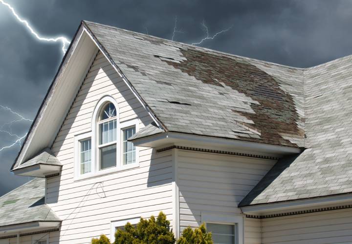 Close-up of hail-damaged asphalt shingles on a Houston home